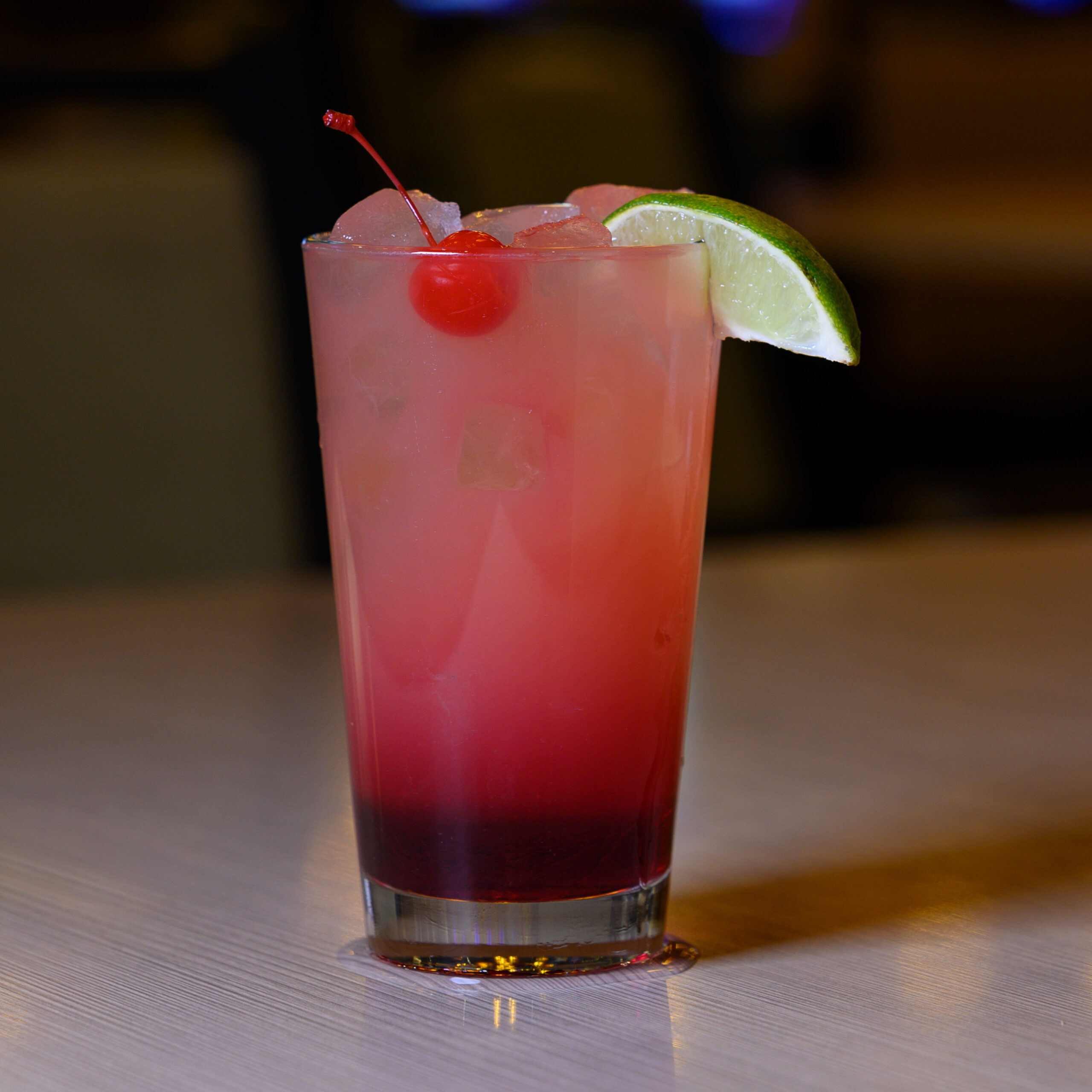 Loft 180's Winter Gem mocktail with a cherry and lime wedge.